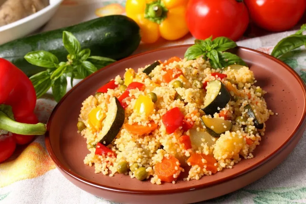 Couscous traditionnel, semoule fine et légumes fondants servis dans un plat en terre cuite