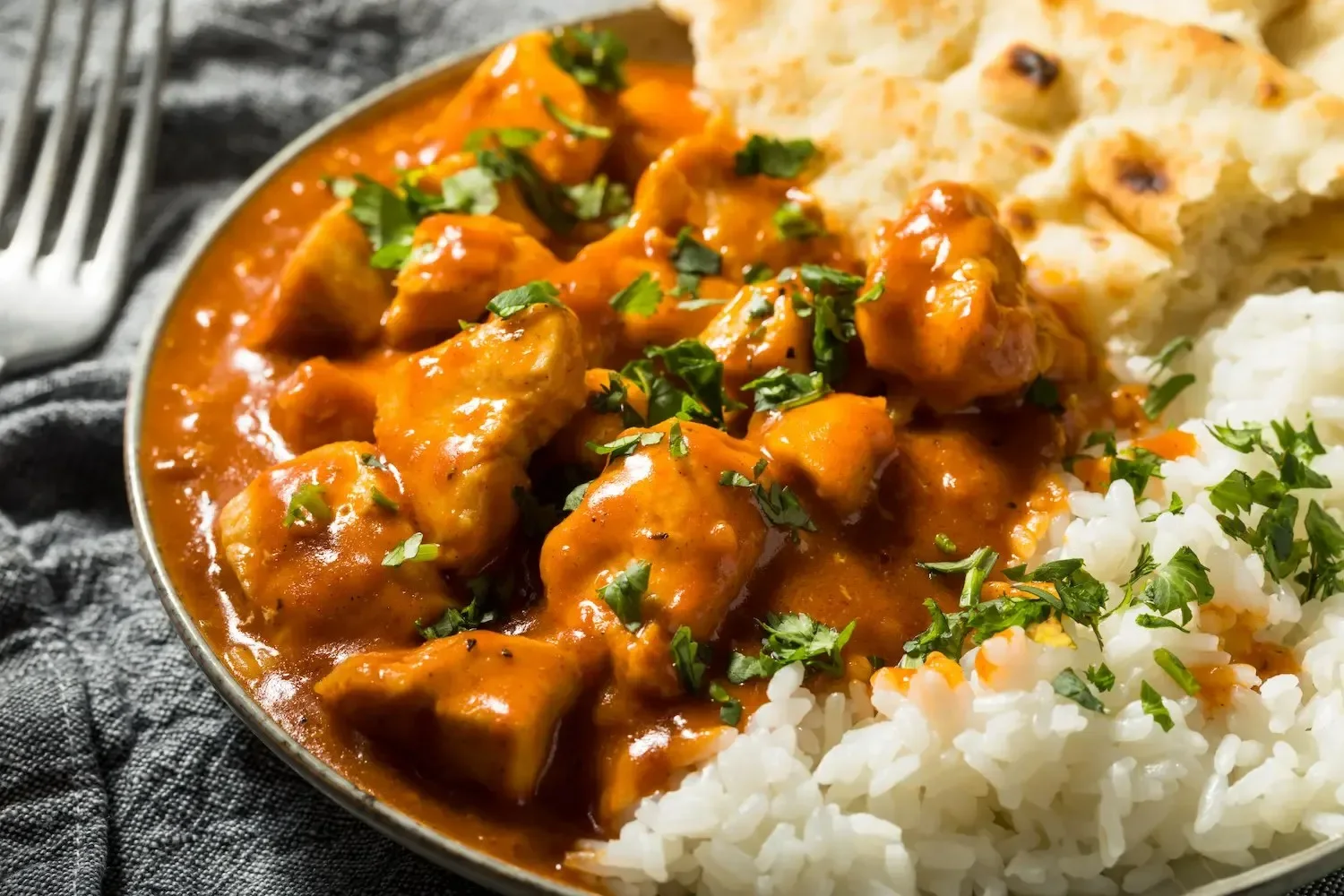 Poulet au beurre indien, sauce tomate crémeuse et épicée, servi avec riz et naan
